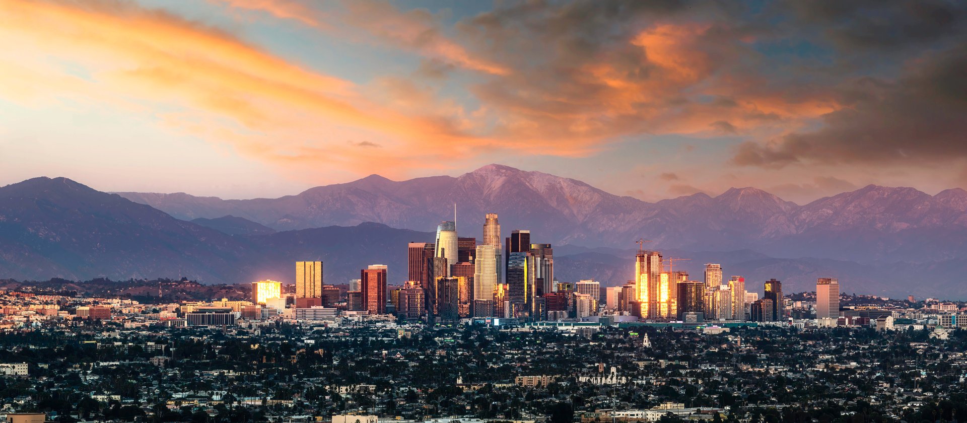 Los Angeles skyline at sunset with the San Gabriel Mountains in the background